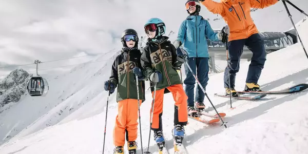 Familie bei der Abfahrt Alpjoch mit Gondel im Hintergrund